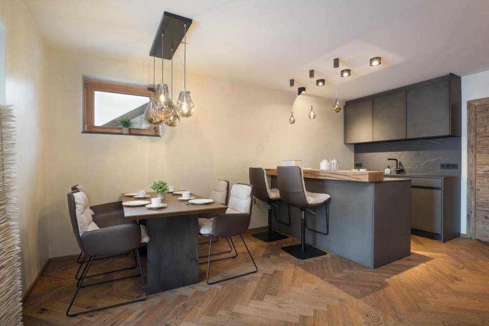 Kompakte moderne Küche mit Frühstücksbar und angrenzendem Essbereich.