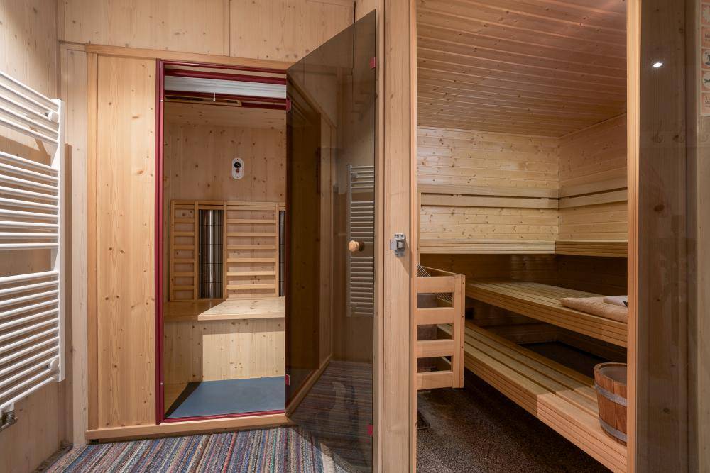 Moderne Sauna mit Holzbänken und Infrarotkabine für Entspannung und Wellness.