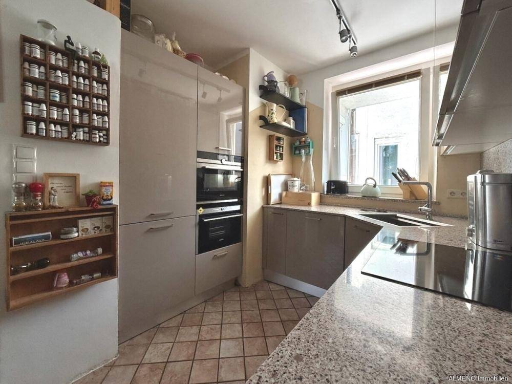 Helle Küche mit modernen Einbauschränken, Granitarbeitsplatte und praktischem Fliesenboden.
