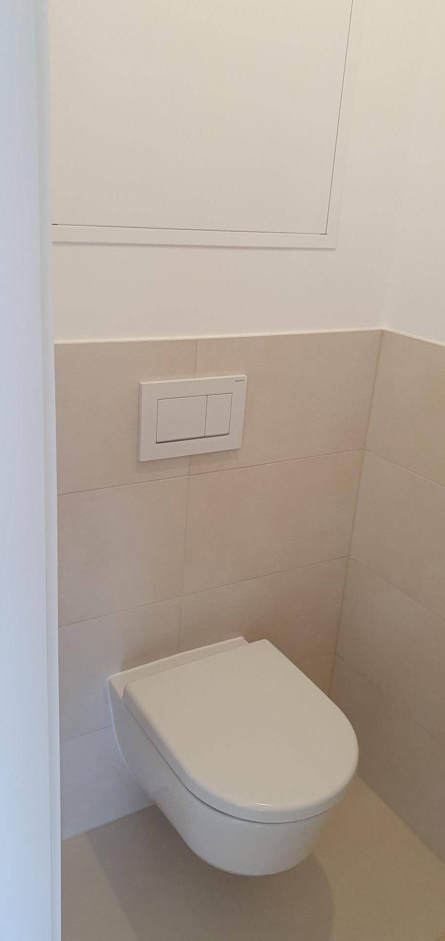 Modernes Gäste-WC mit wandhängender Toilette und hellen Fliesen im unteren Bereich.
