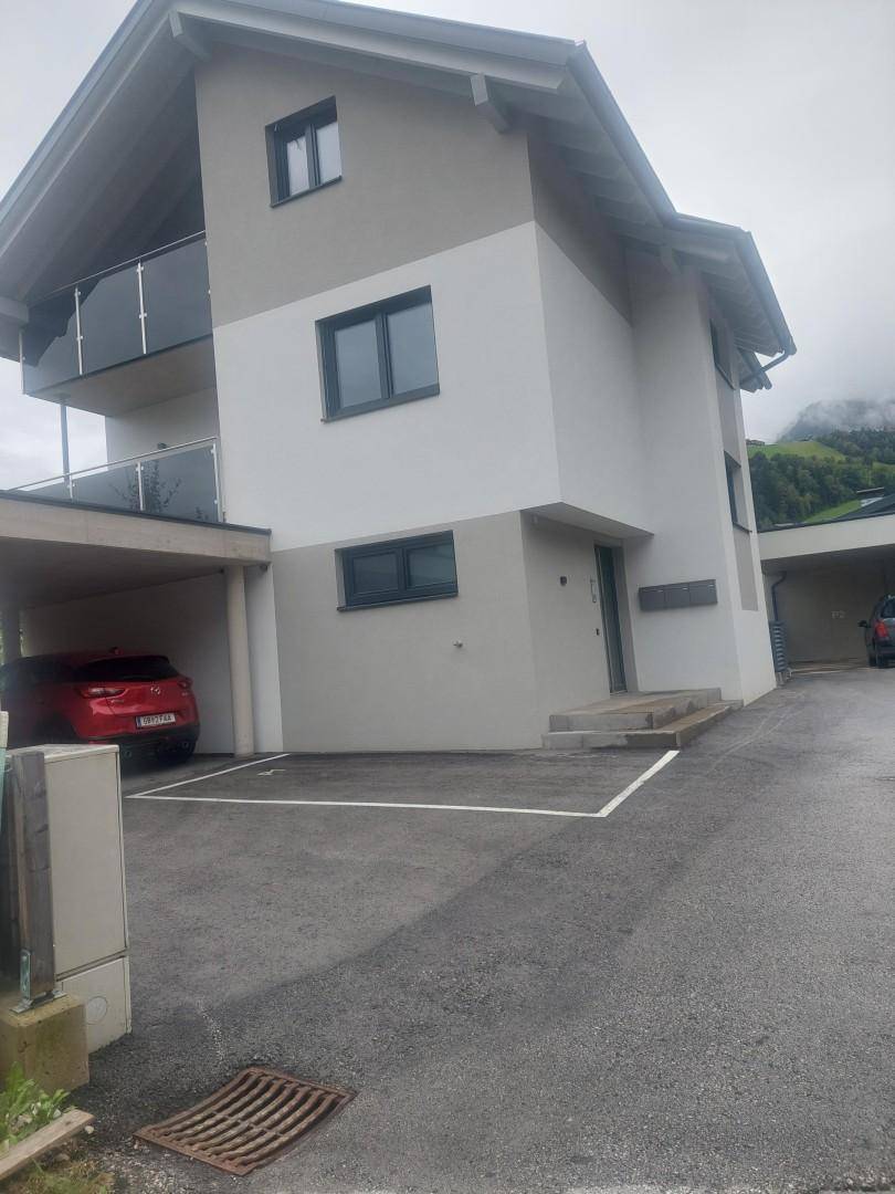 Neues Wohnhaus mit Carport und gepflastertem Stellplatz, eingebettet in die Natur.