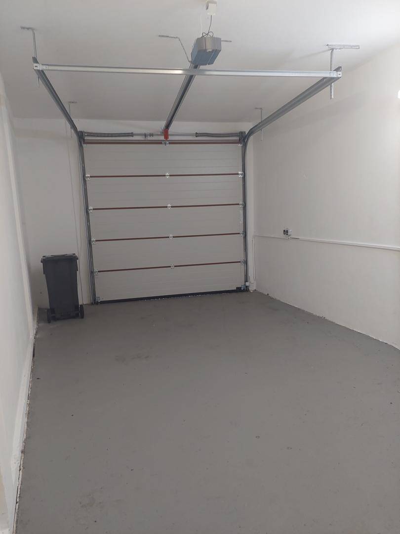 Geräumige Garage mit automatischem Tor und ausreichend Platz für ein Fahrzeug.