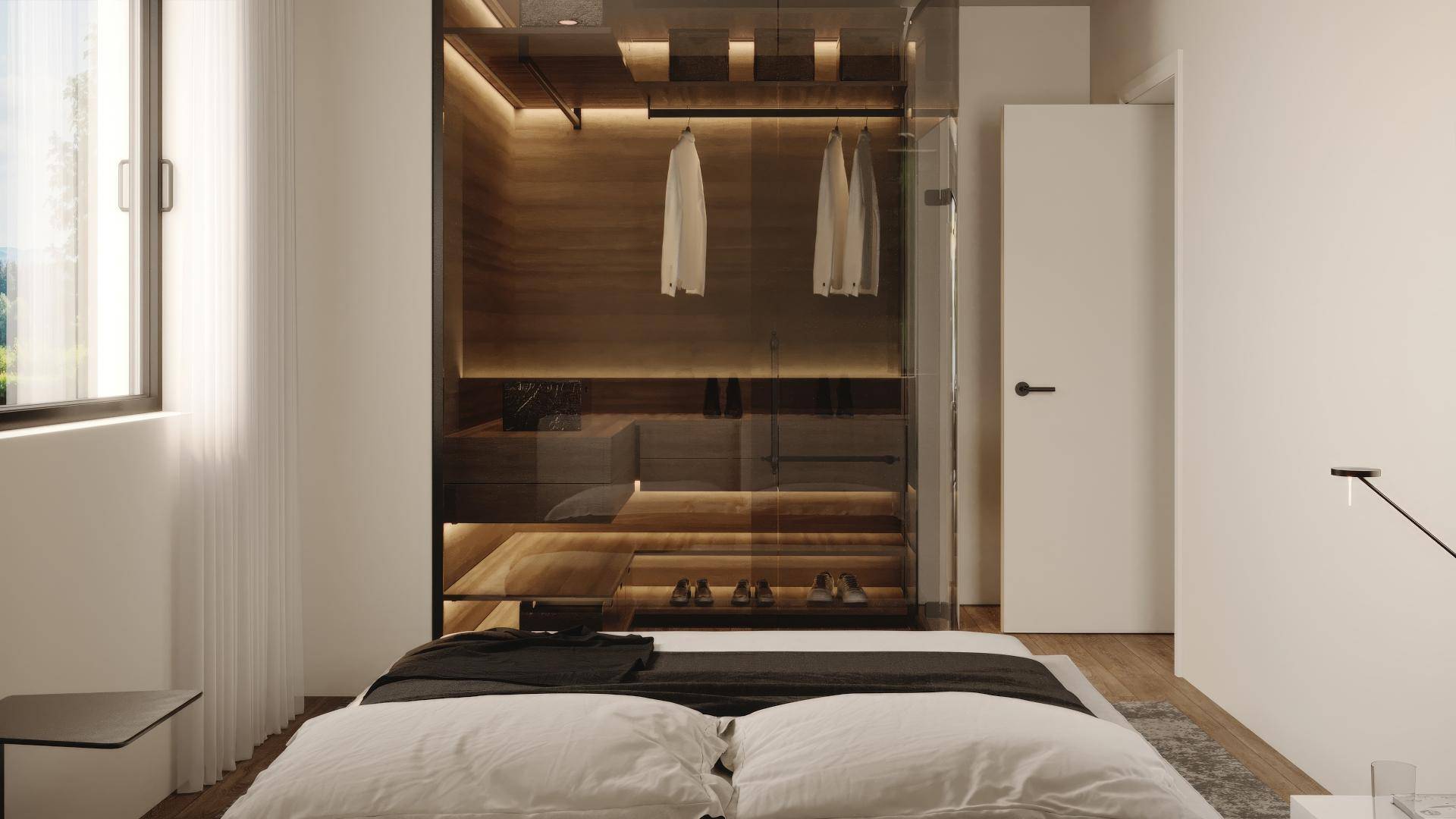 Schlafzimmer mit integriertem, begehbarem Kleiderschrank hinter Glasfronten und Holzelementen.