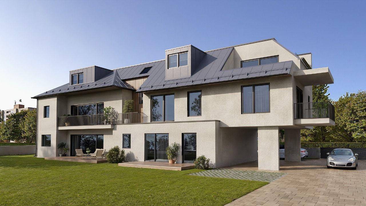 Moderne Architektur eines Mehrfamilienhauses mit Balkonen, großer Rasenfläche und Parkplätzen.
