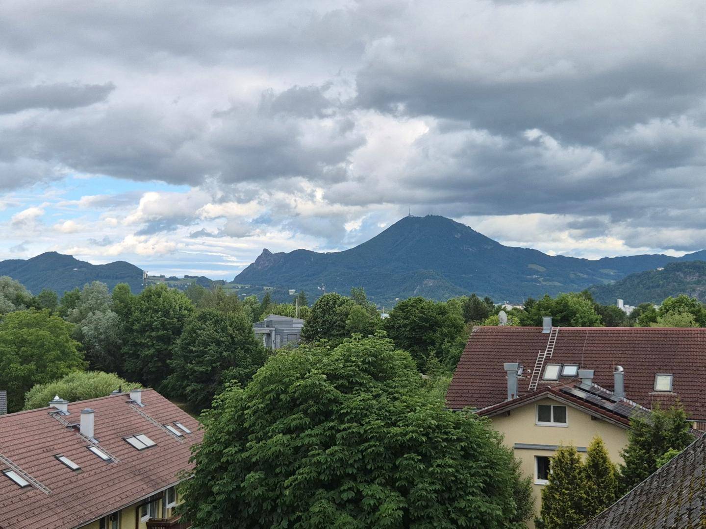 Panoramablick auf die umliegende Berglandschaft und Dächer der Nachbarschaft.