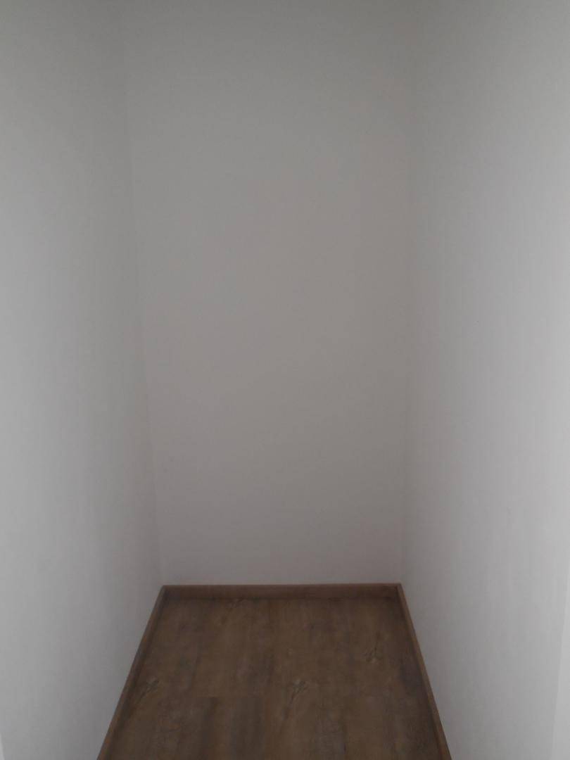 Kleiner, leerer Abstellraum mit Laminatboden und weißen Wänden, ideal für zusätzlichen Stauraum.