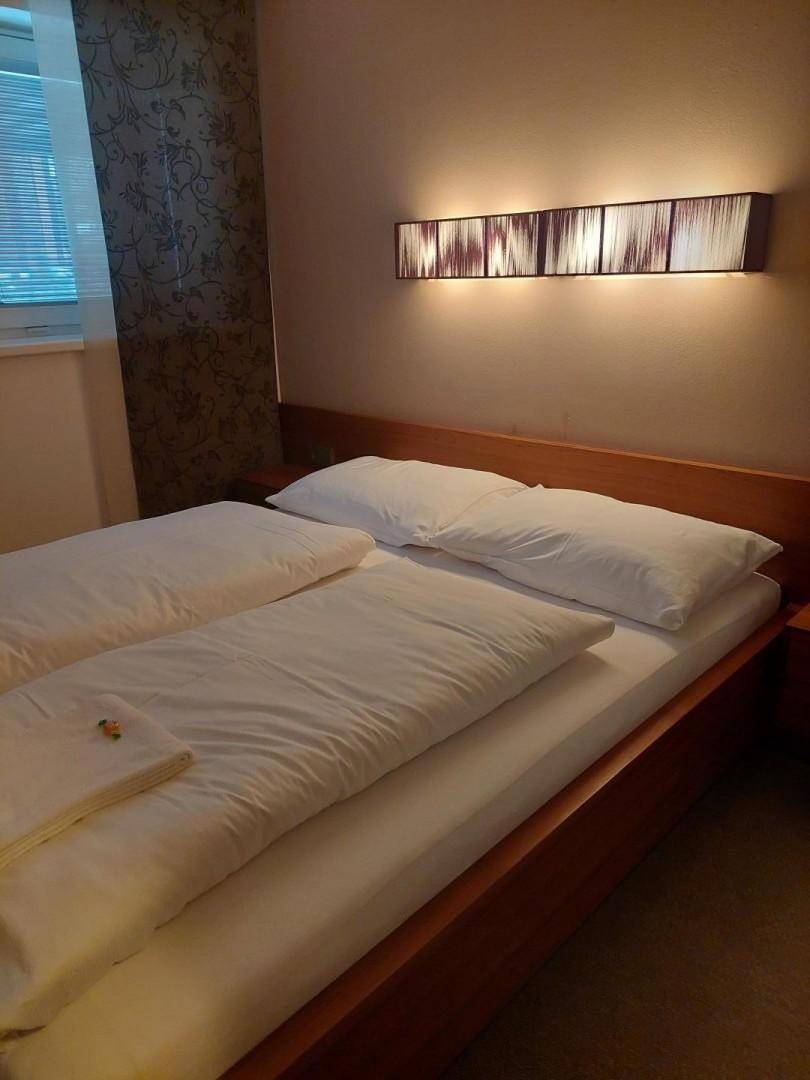 Gemütliches Schlafzimmer mit Doppelbett, Nachttischlampen und dezenter Wanddekoration.