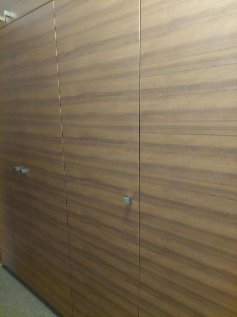 Eingebauter Holzschrank mit schlichten Griffen und glatter Oberfläche.
