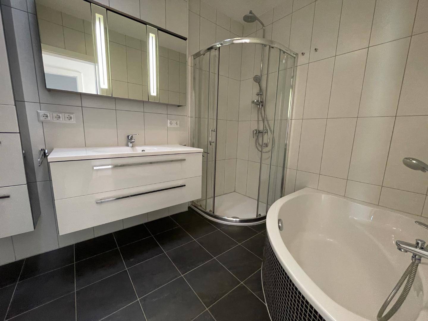 Modernes Badezimmer mit Dusche, Badewanne und Doppelwaschbecken.