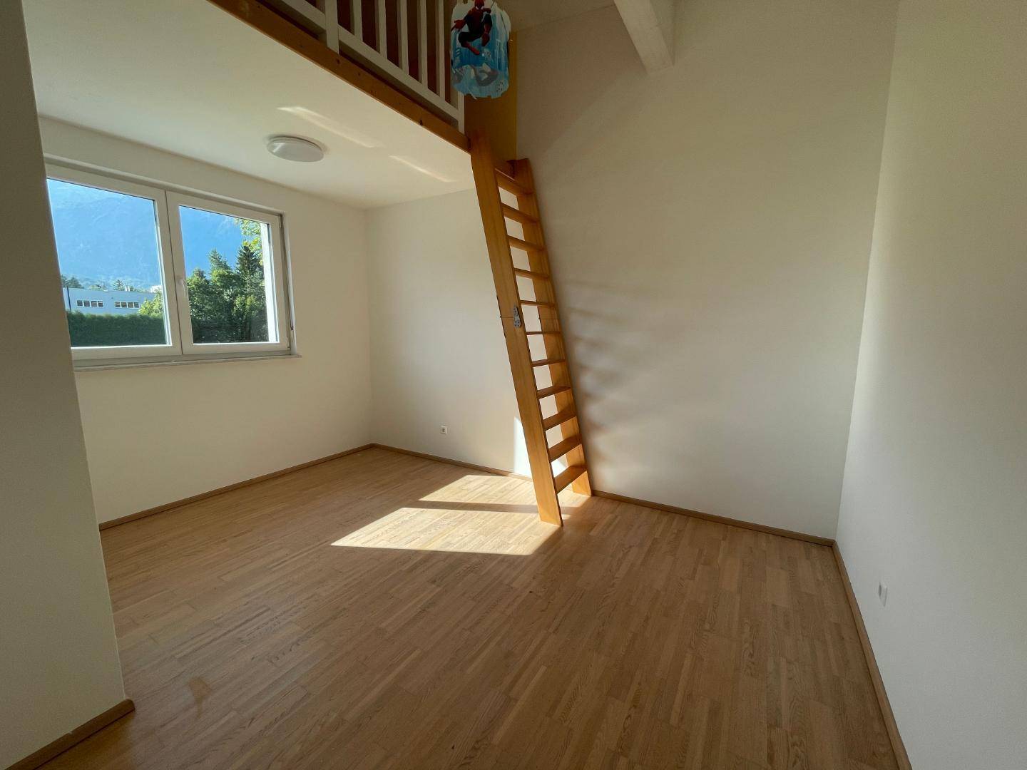 Kinderzimmer mit Holzboden, Hochbett und Blick auf die umliegende Berglandschaft.