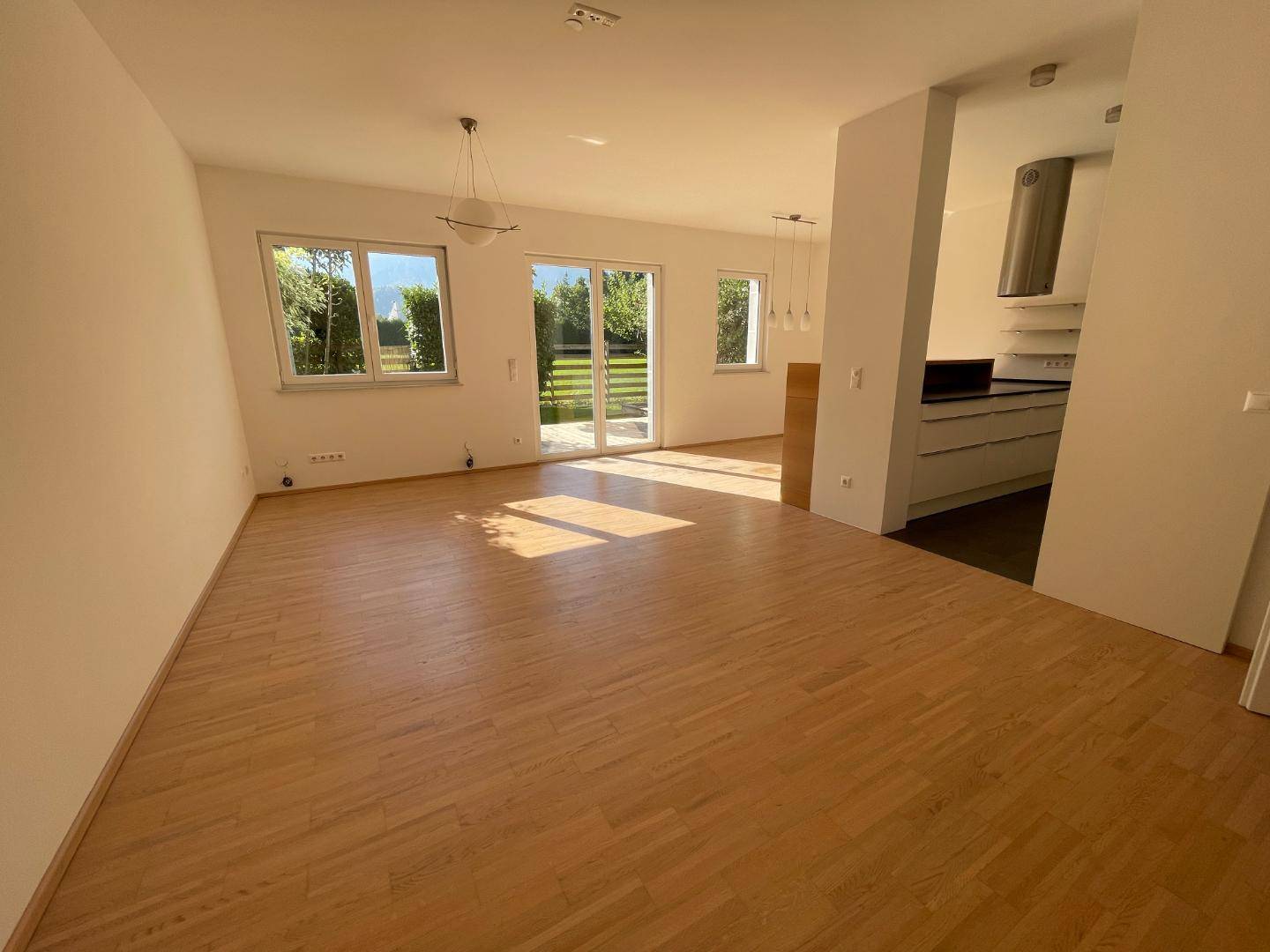Offener Wohn- und Essbereich mit Zugang zum Garten und viel Tageslicht.