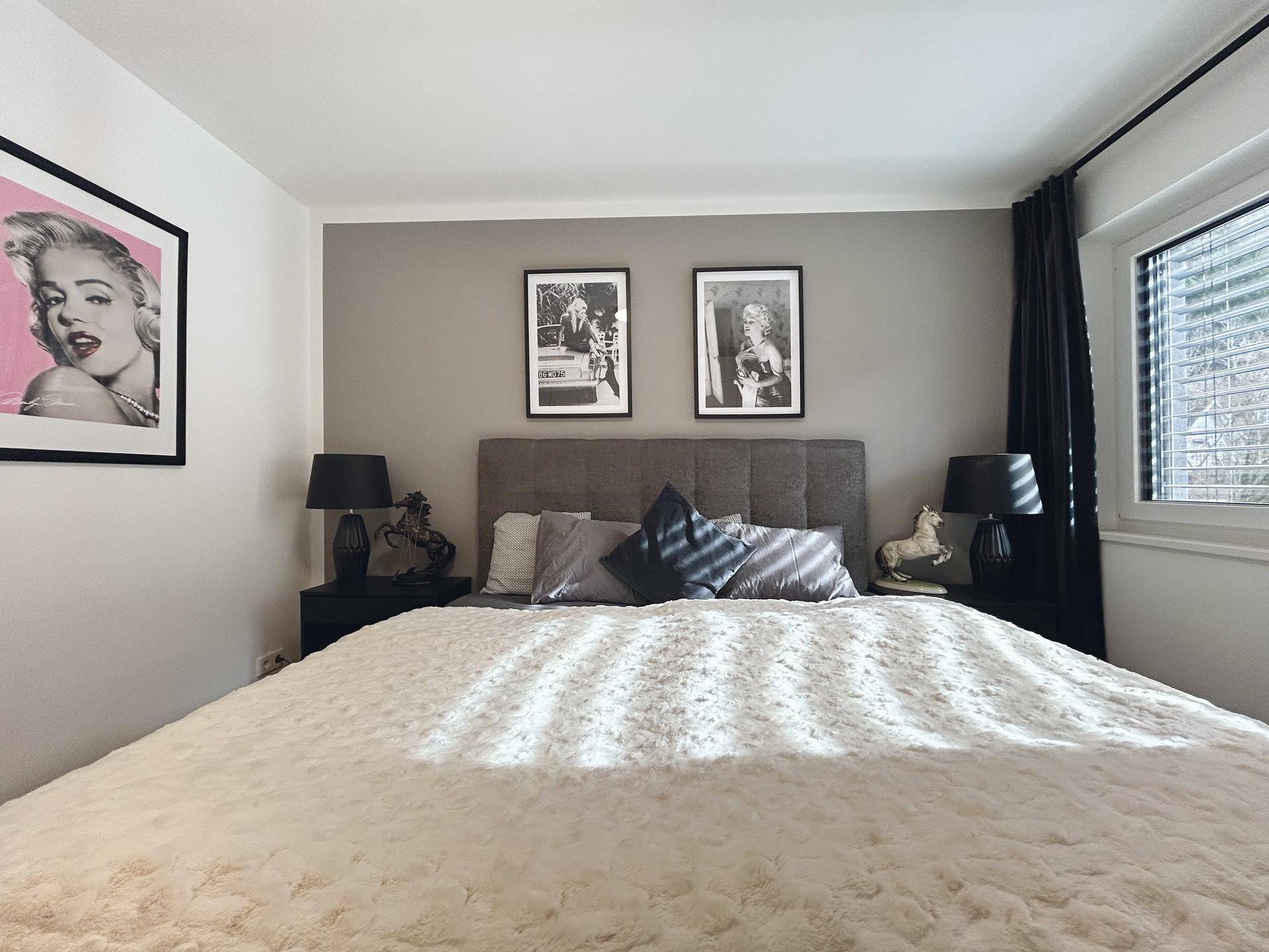 Gemütliches Schlafzimmer mit großem Bett, Nachttischen und Fenster für natürliches Licht.