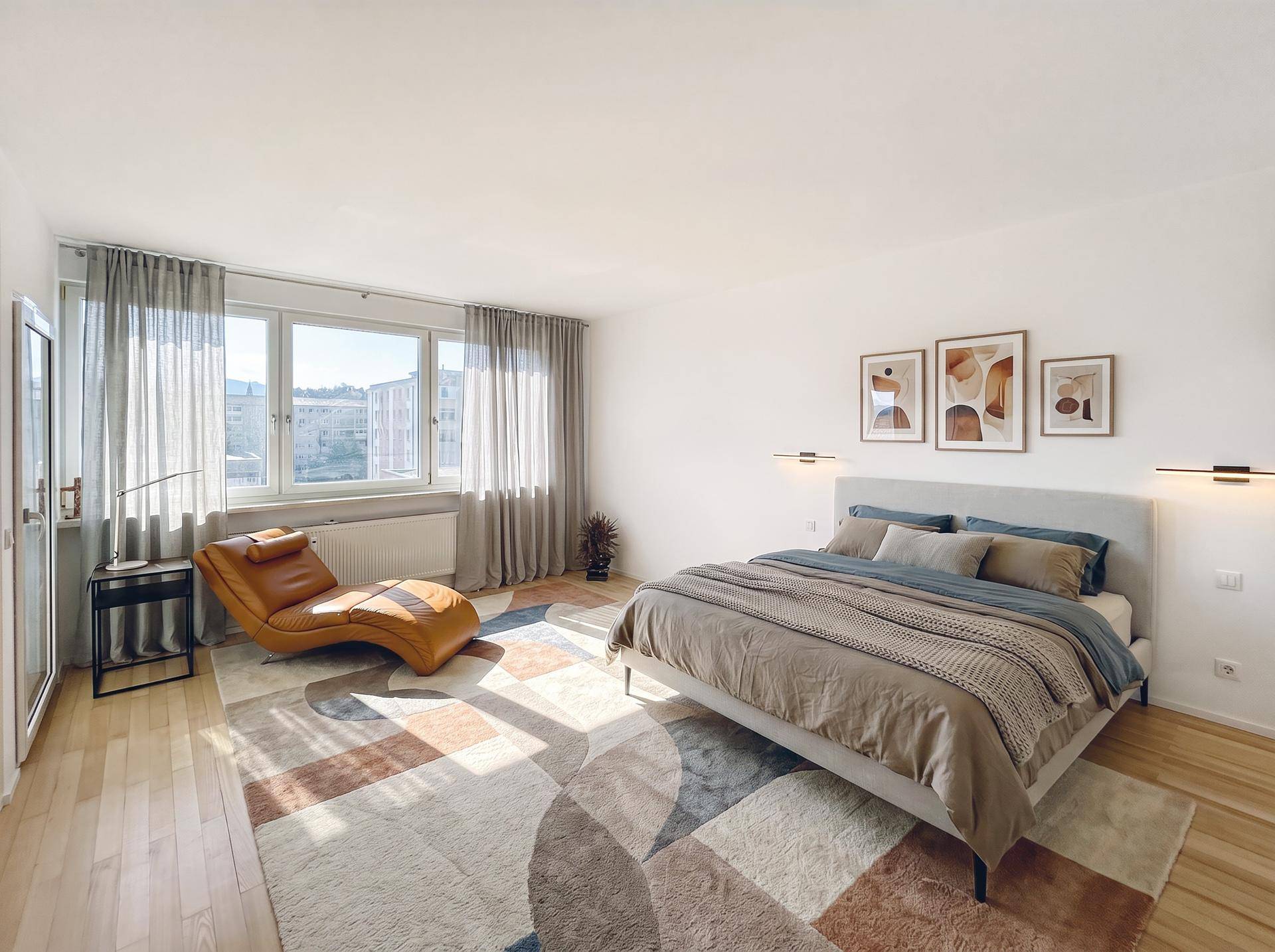 Geräumiges Schlafzimmer mit großem Fenster, Doppelbett und bequemer Chaiselongue.