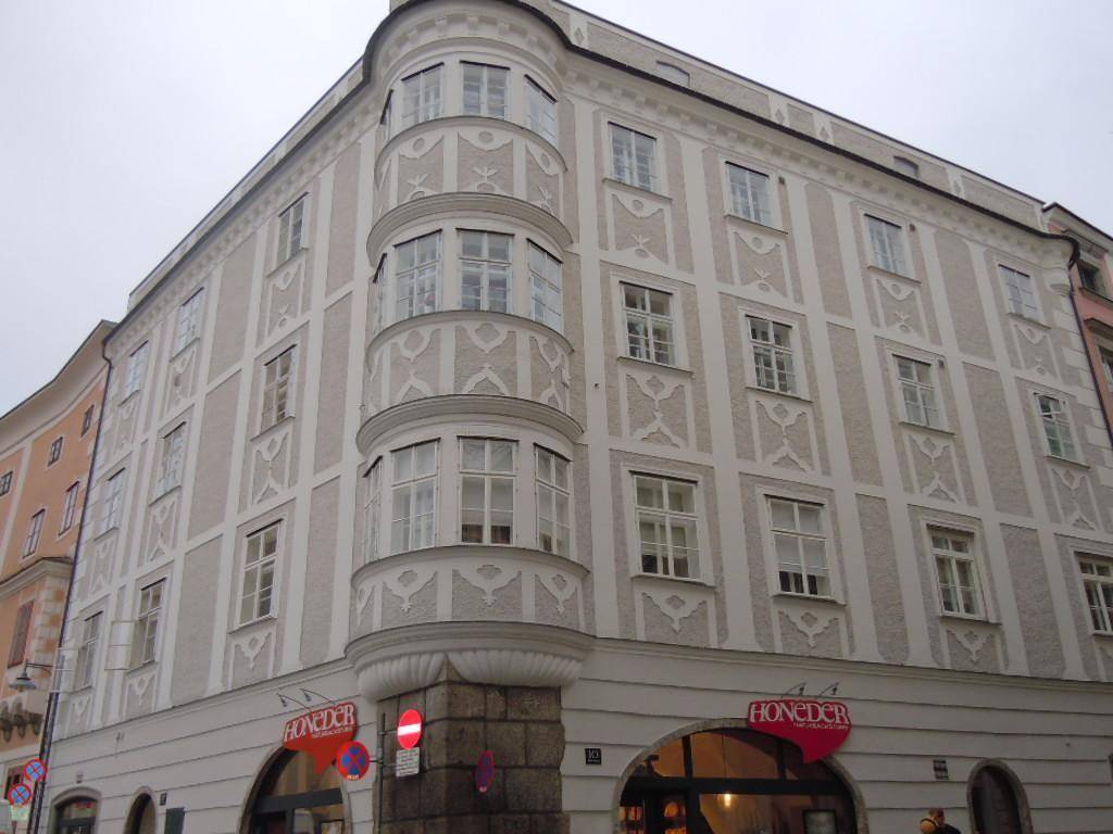 Historisches Eckgebäude mit reich verzierter Fassade und großen Fenstern in der Stadt.