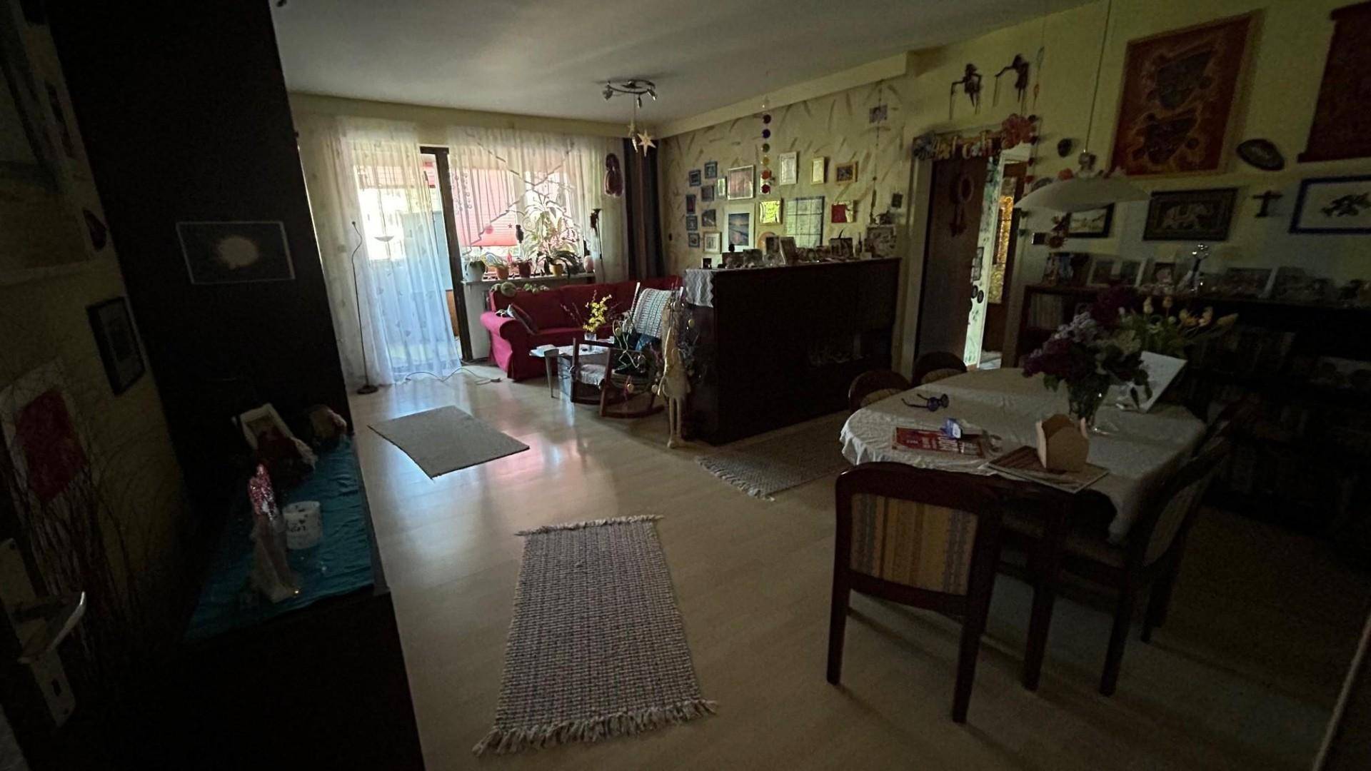 Langer Wohn- und Essbereich mit viel Tageslicht, Parkettboden und Zugang zum Außenbereich.