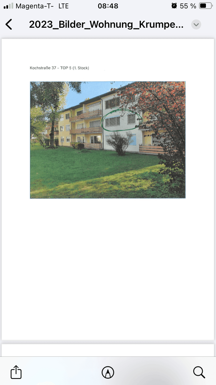 Ansicht eines Mehrfamilienhauses mit Balkonen und gepflegter Grünfläche, umgeben von Bäumen.