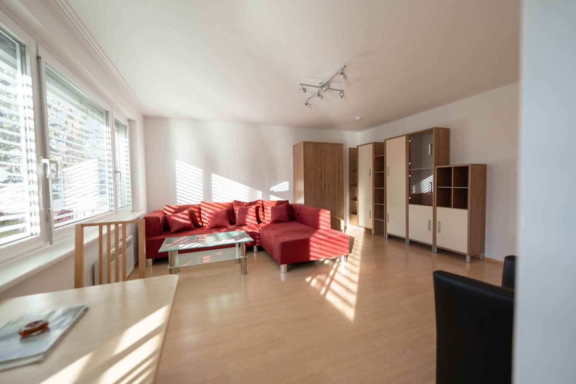 Lichtdurchfluteter Wohn- und Essbereich mit hellem Holzfußboden und modernen Möbeln.