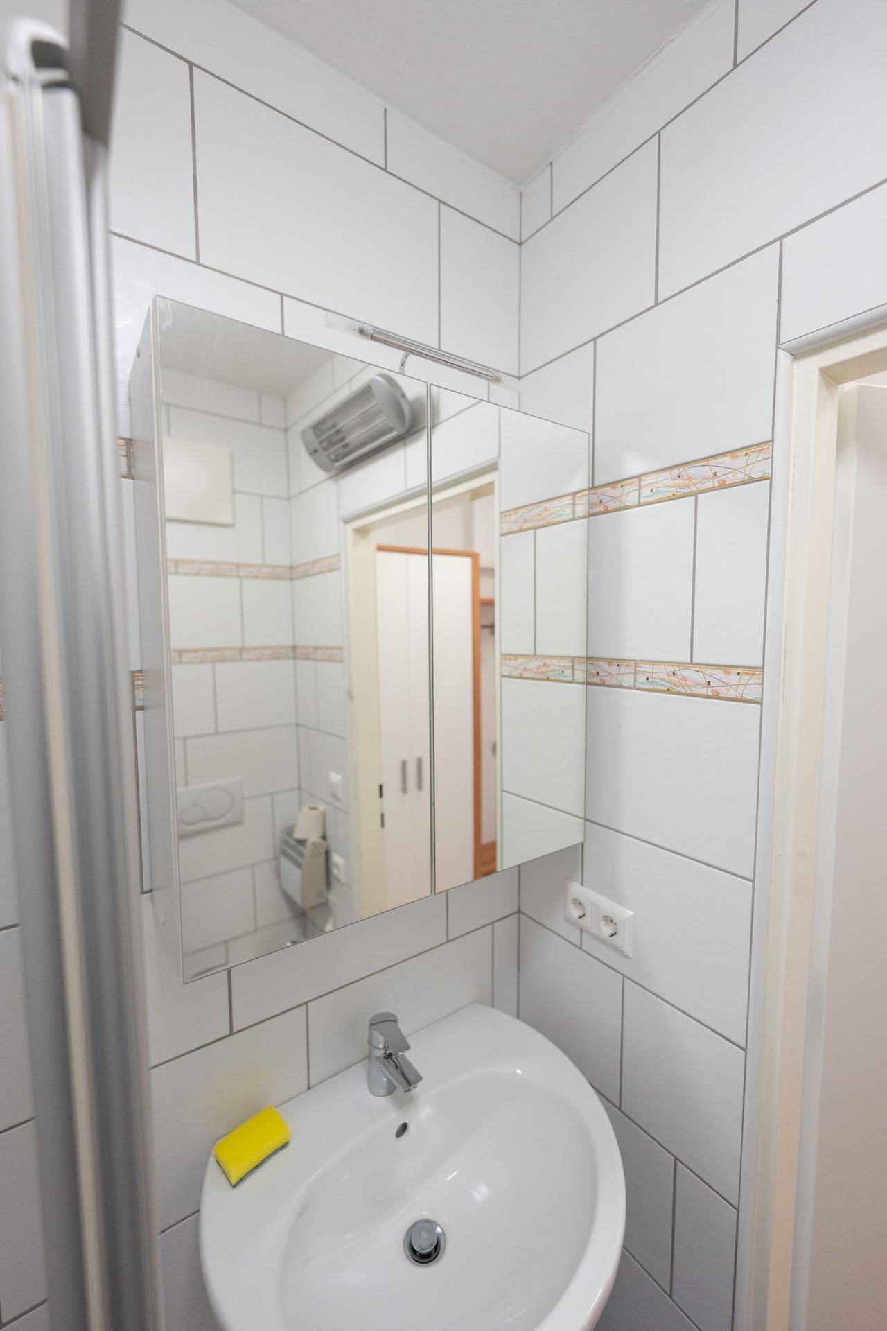 Waschbecken mit Spiegelschrank und Beleuchtung im Badezimmer.