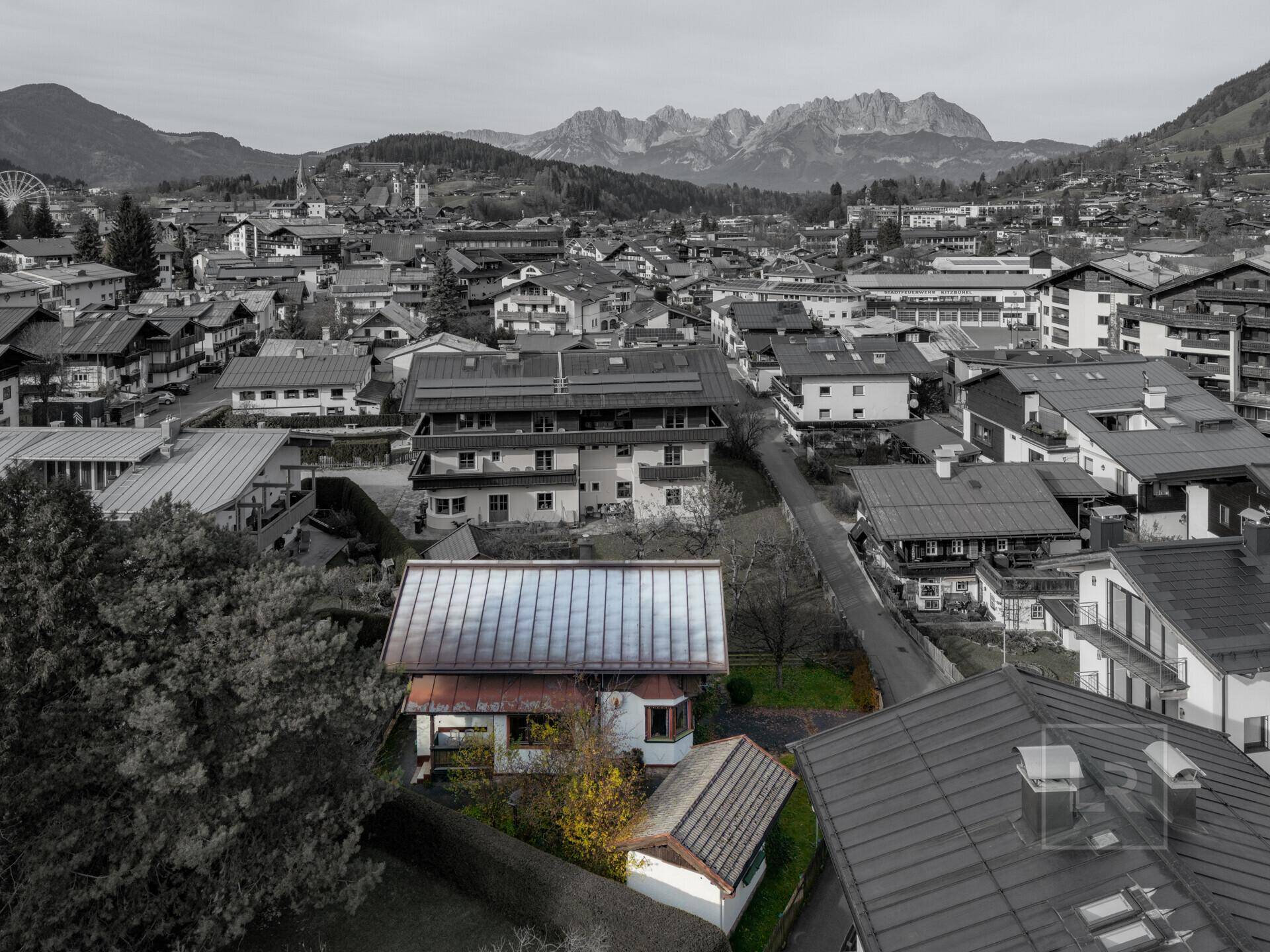 Weitläufige Luftaufnahme des Hauses in einer städtischen Umgebung mit beeindruckendem Bergpanorama.