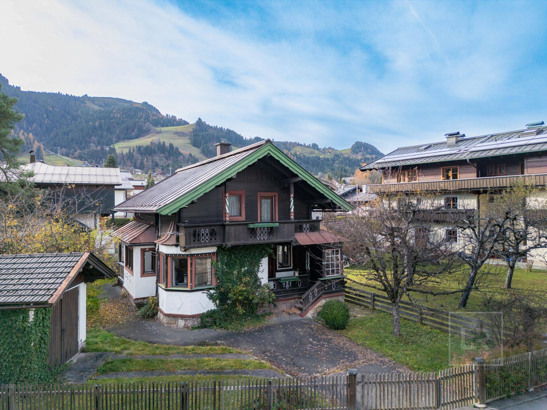 Traditionelles Haus im alpinen Stil mit Holzbalkonen und Blick auf die umliegenden Berge.