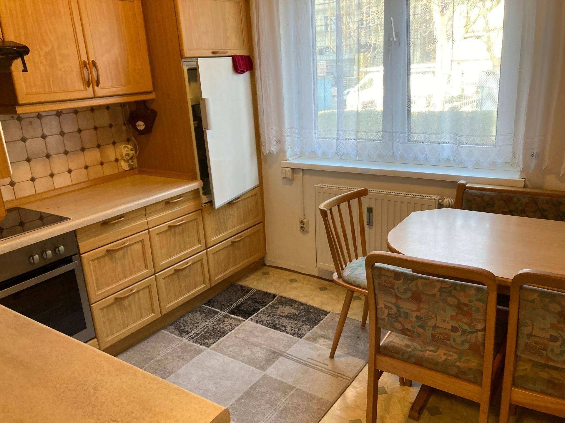 Gemütliche Wohnküche mit Essbereich, Fenster und integriertem Kühlschrank.