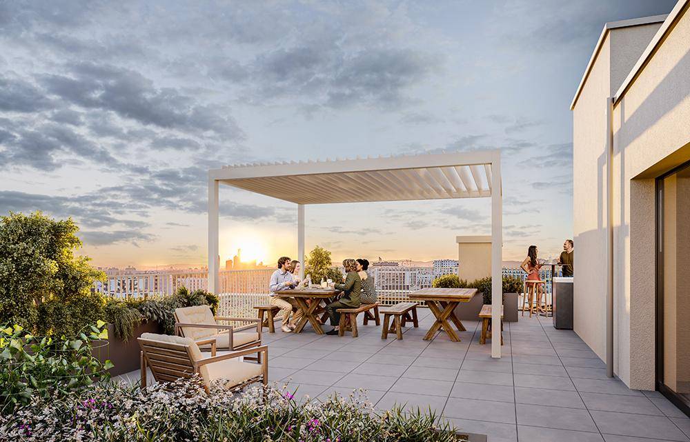 Geräumige Dachterrasse mit Essbereich unter einer Pergola und weitem Stadtblick bei Sonnenuntergang.