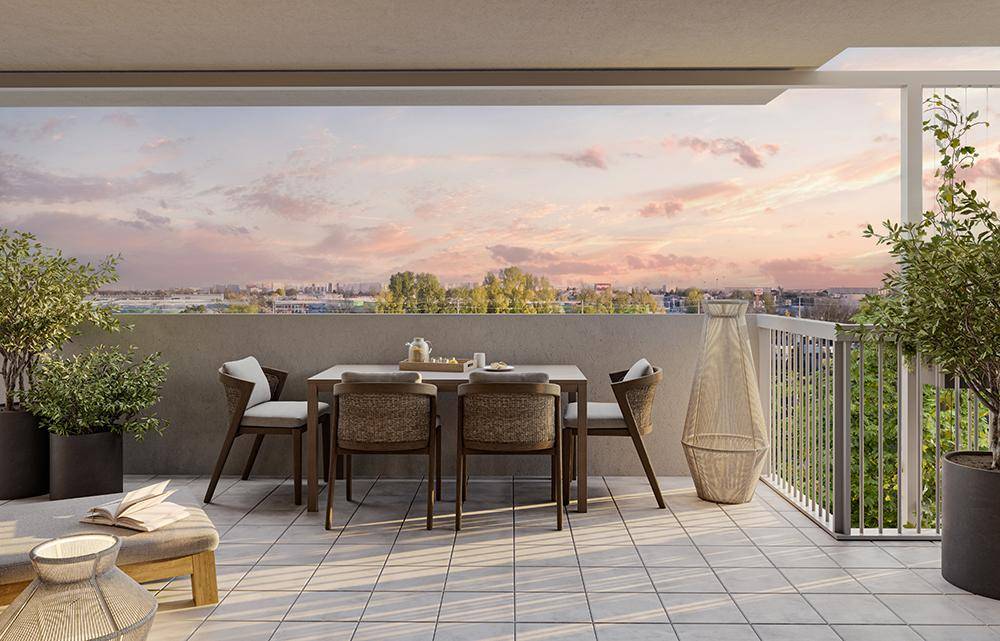 Geräumige Terrasse mit Essbereich und weitem Blick über die Stadt bei Sonnenuntergang.
