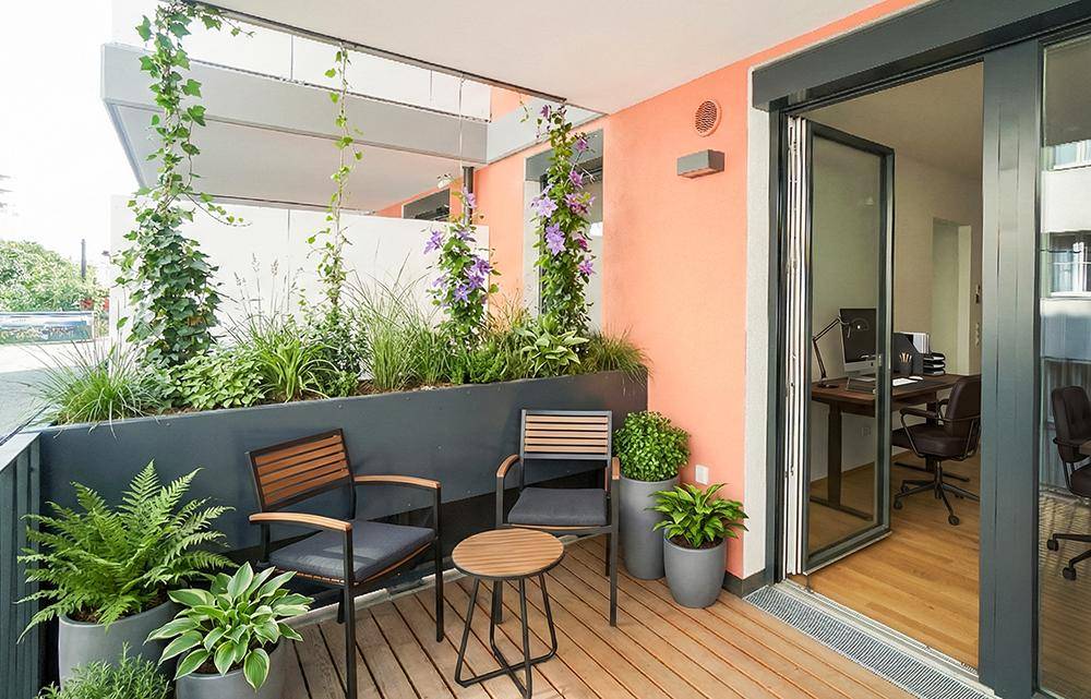Attraktive Terrasse mit Holzdeck, Sitzgelegenheiten und üppiger Bepflanzung, ideal zum Entspannen im Freien.