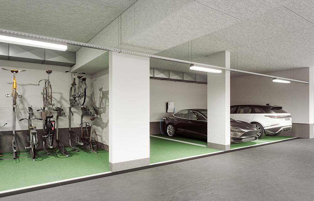 Tiefgarage mit Stellplätzen für Autos und Fahrräder, inklusive Ladestationen für Elektrofahrzeuge.
