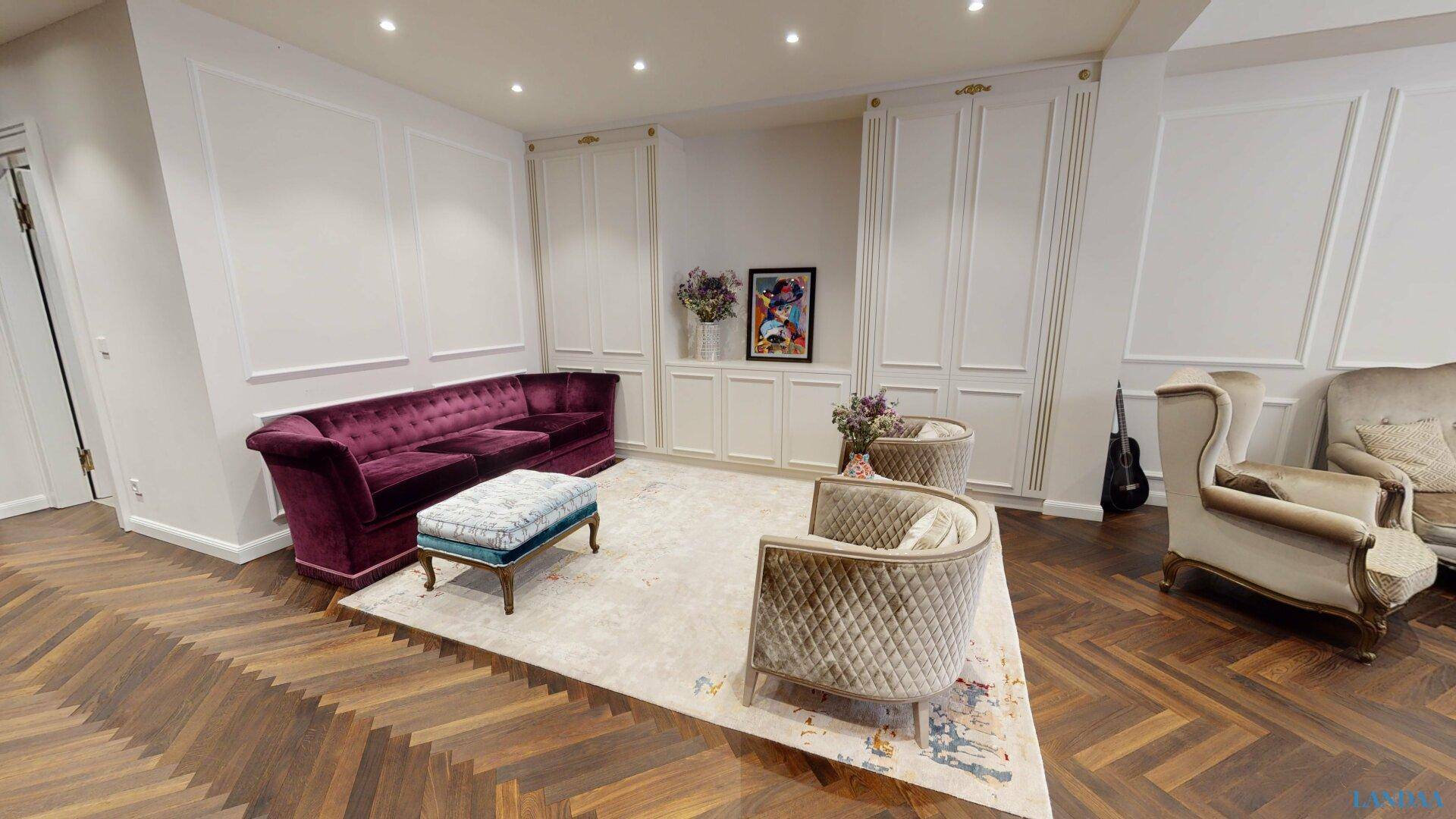 Stilvolles Wohnzimmer mit violettem Sofa, Parkettboden und eleganten Wandvertäfelungen.