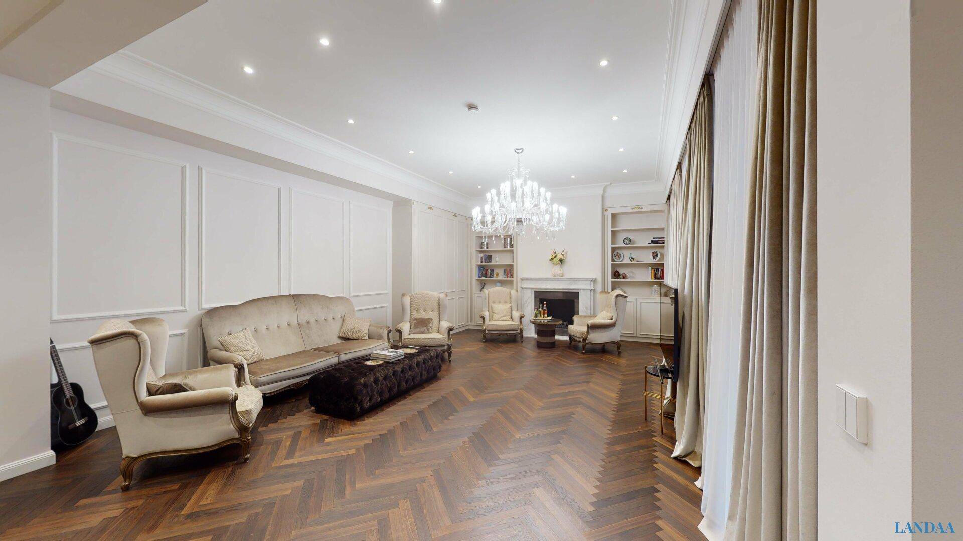 Klassisch eingerichtetes Wohnzimmer mit Kamin, Stuckdecke und elegantem Fischgrätparkett.