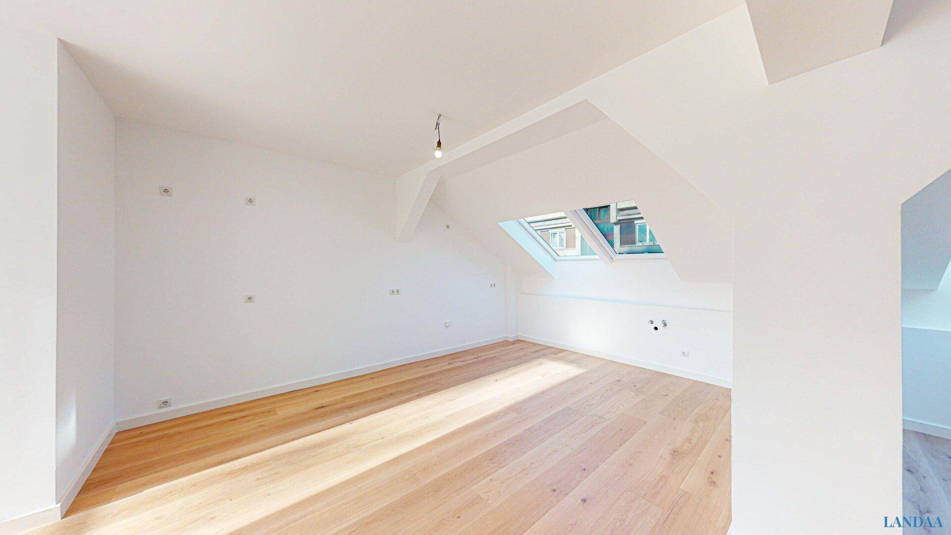 Leerer Raum im Dachgeschoss mit Holzboden und Dachfenstern, bereit zur individuellen Gestaltung.