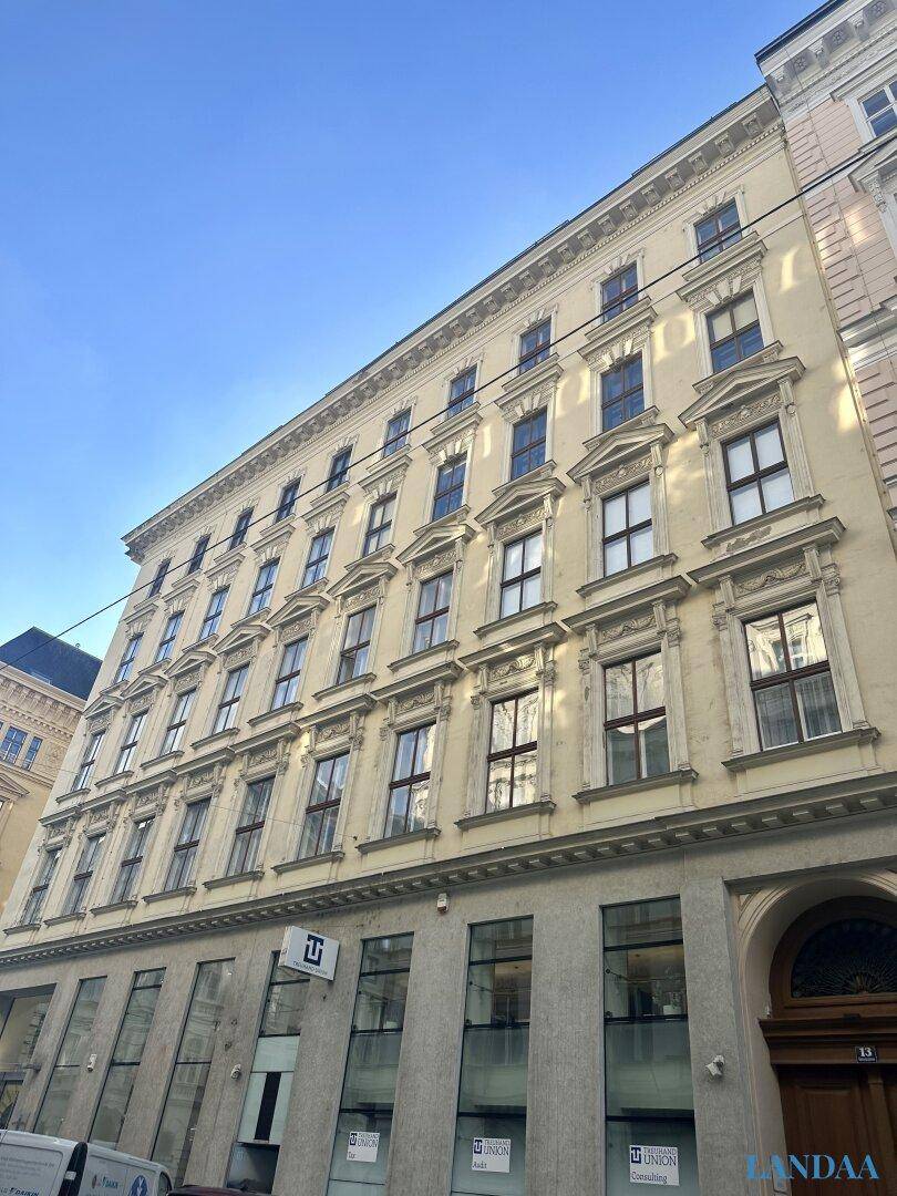 Eindrucksvolle Fassade eines historischen Altbaus mit vielen Fenstern und klassischer Architektur.