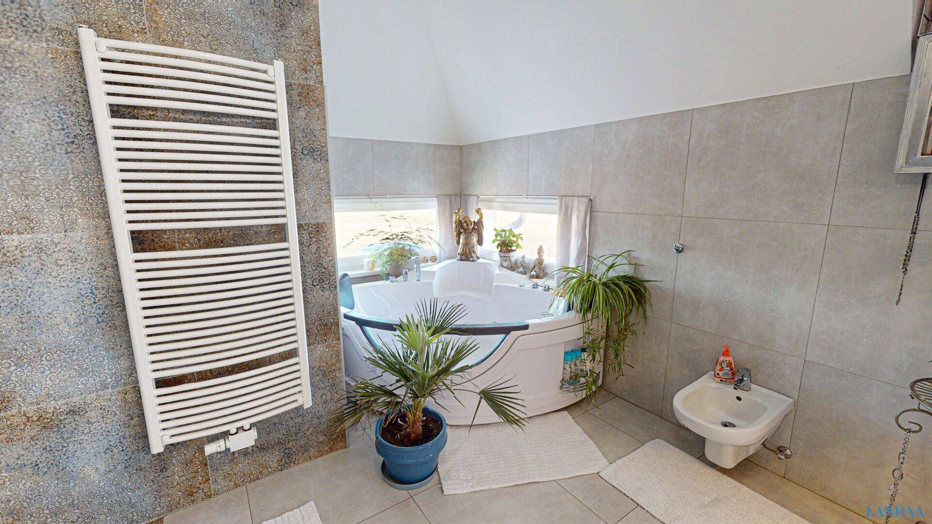 Geräumiges Badezimmer mit Eckbadewanne, Bidet und beheiztem Handtuchhalter.