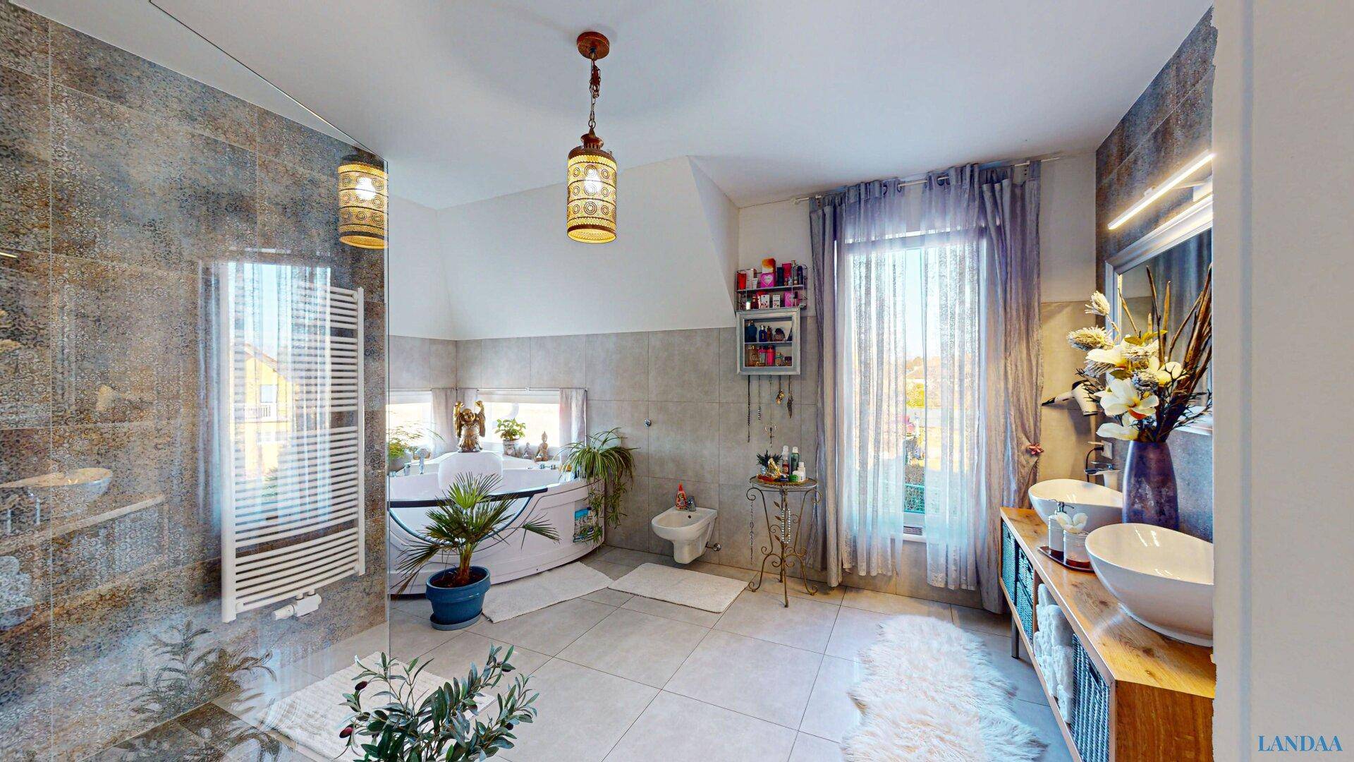 Großes Badezimmer mit Eckbadewanne, Doppelwaschbecken und modernen Fliesen.