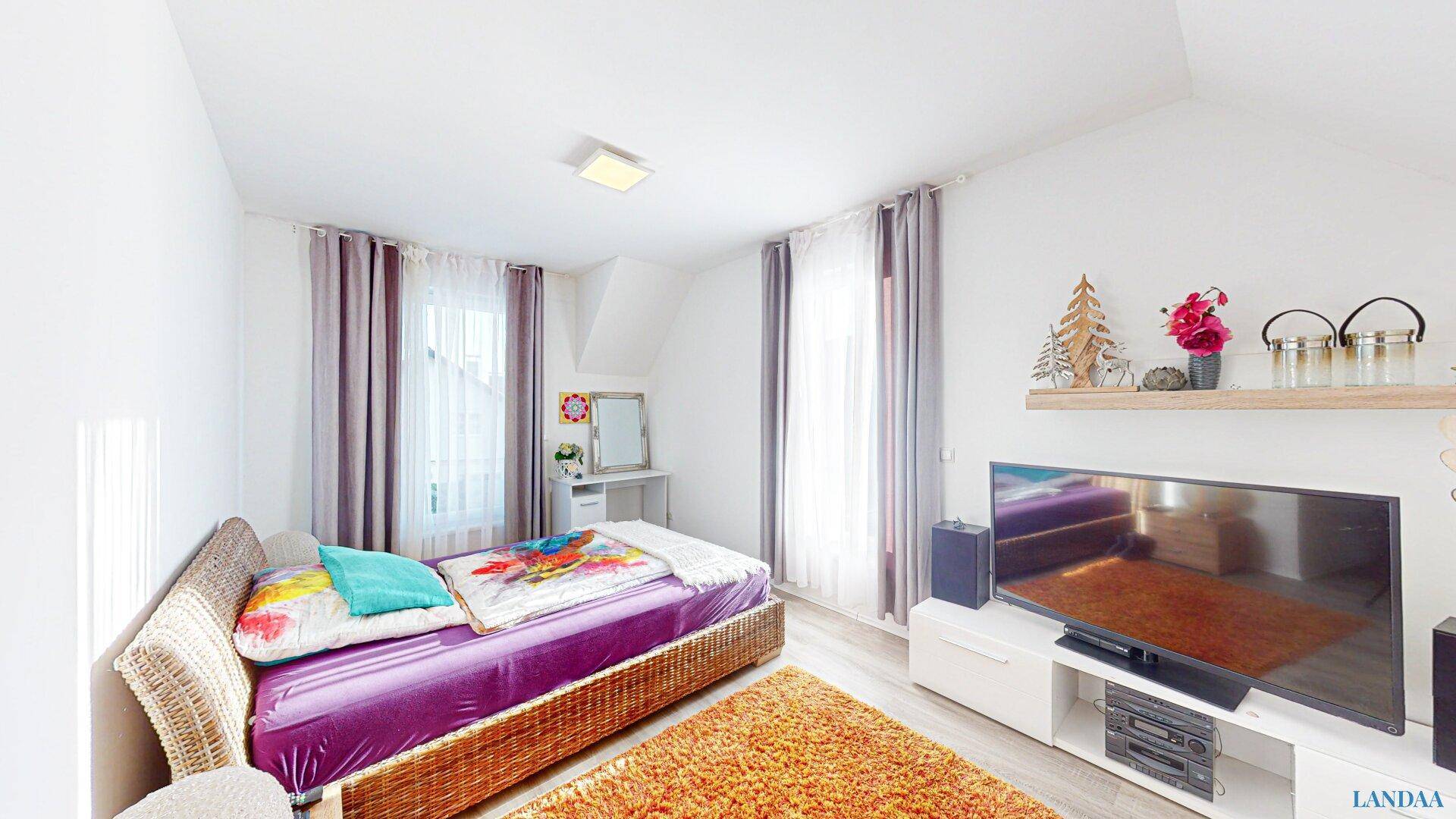 Freundliches Kinder- oder Gästezimmer mit Einzelbett, Teppich und Fenster.
