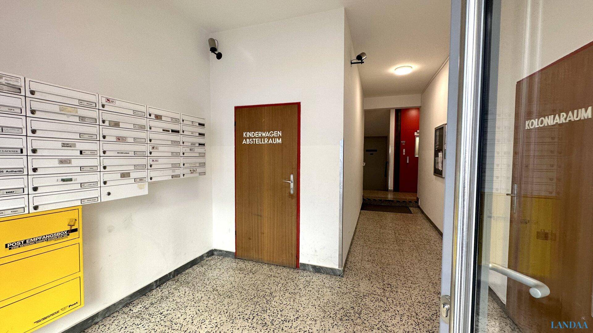 Eingangsbereich des Gebäudes mit Briefkästen und Überwachungskameras.