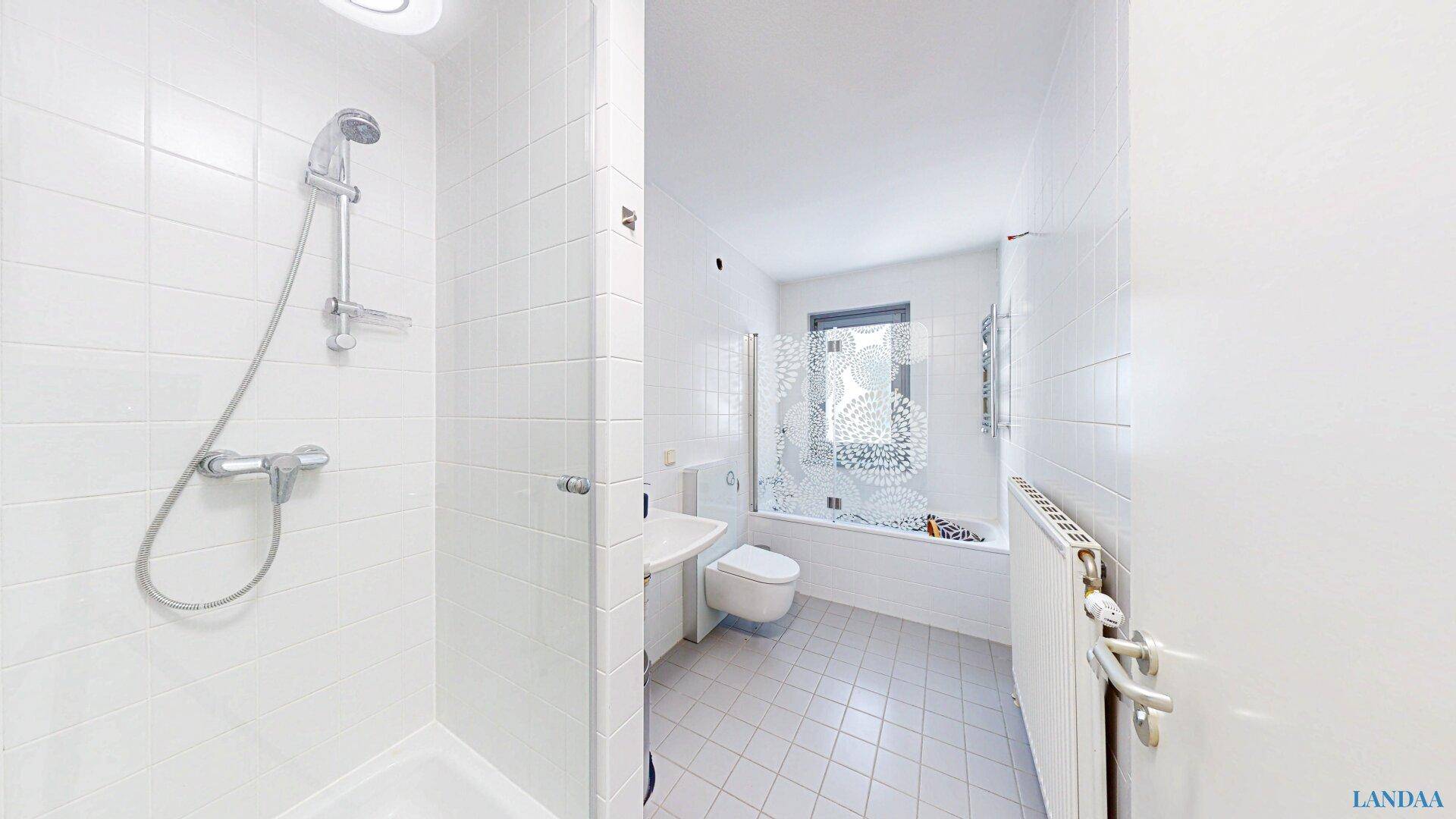 Funktionales Badezimmer mit Dusche, Badewanne und WC.
