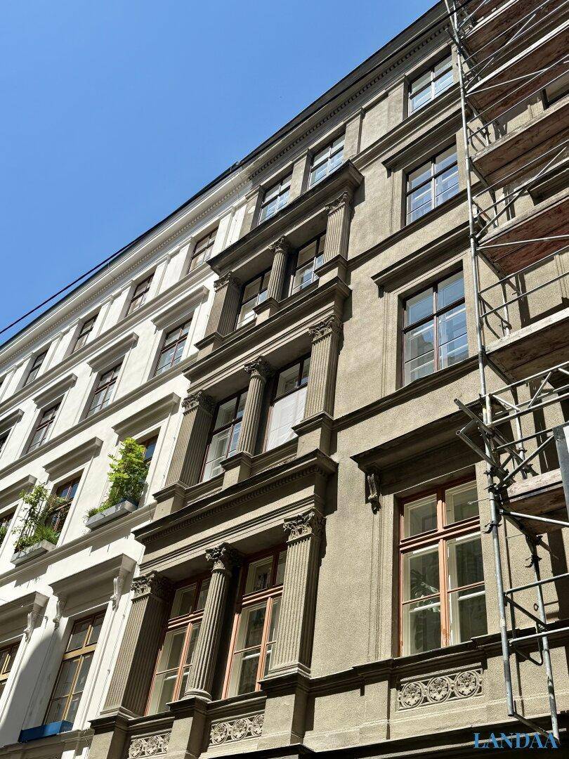 Historische Fassade eines Gebäudes mit aufwendigen Verzierungen und Gerüst.
