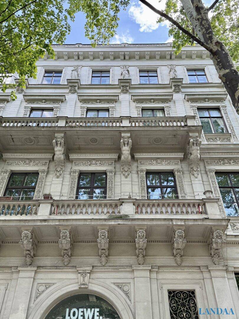 Prunkvolle Fassade eines Altbaus mit reich verzierten Balkonen und Fenstern.