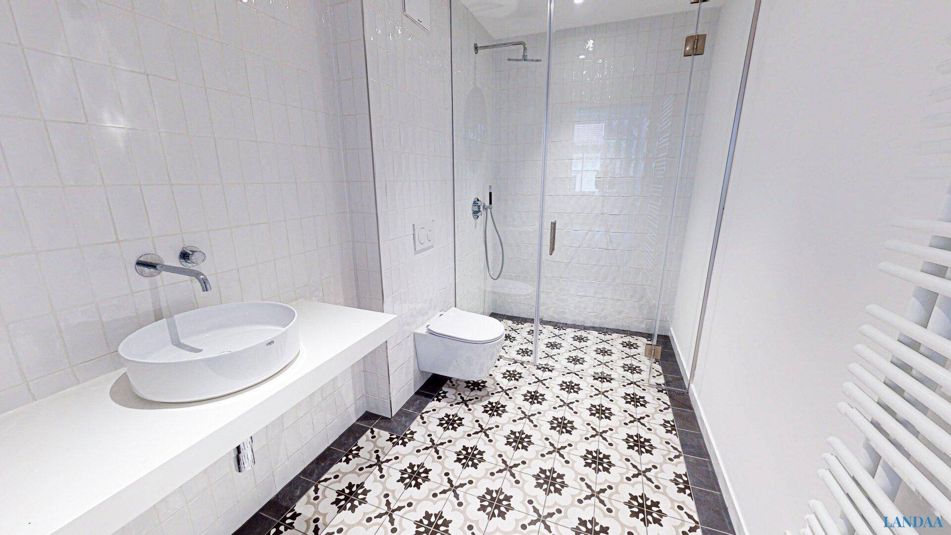 Modernes Badezimmer mit begehbarer Dusche, stilvollen Fliesen und Handtuchheizkörper.