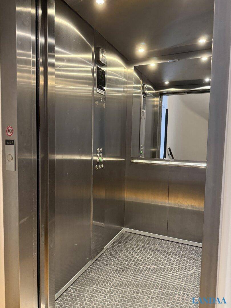 Moderner Aufzug mit Edelstahlverkleidung und Spiegelfläche im Gebäude.