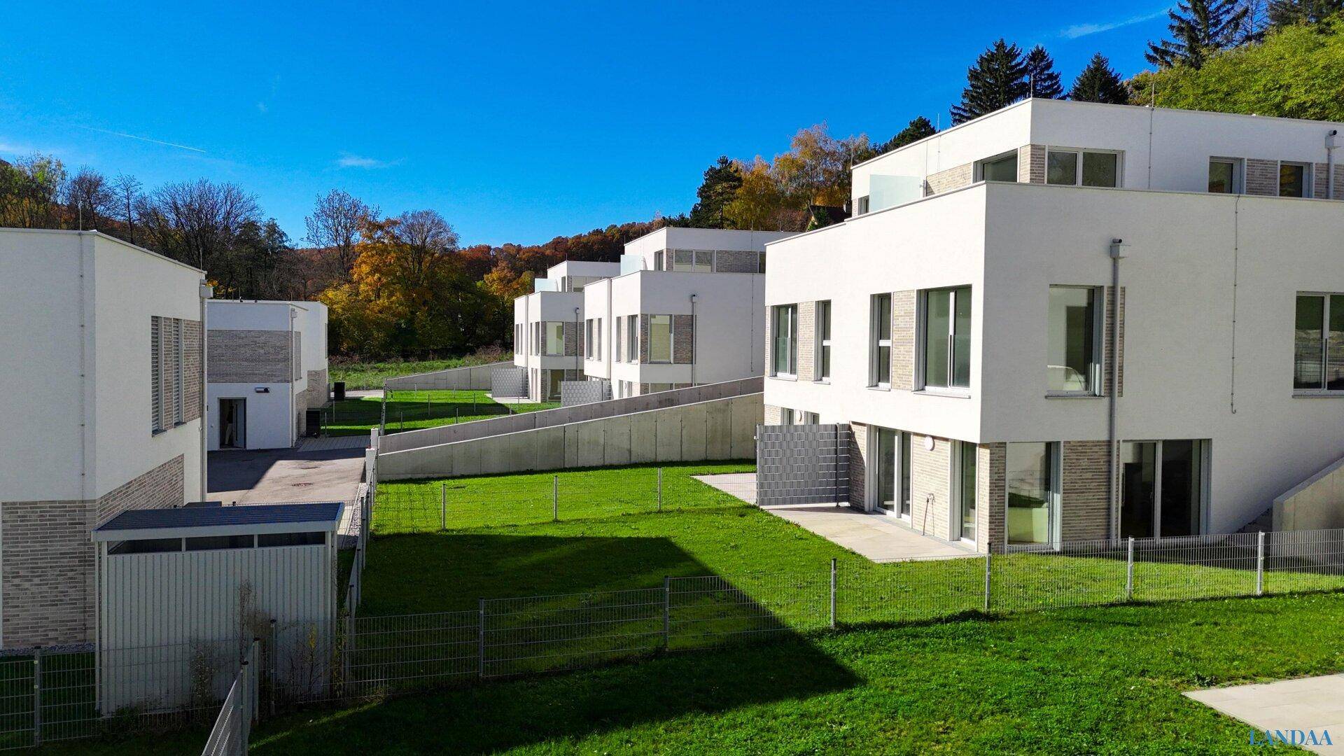 Neubauten mit moderner Architektur, großen Fenstern und angrenzenden Grünflächen.