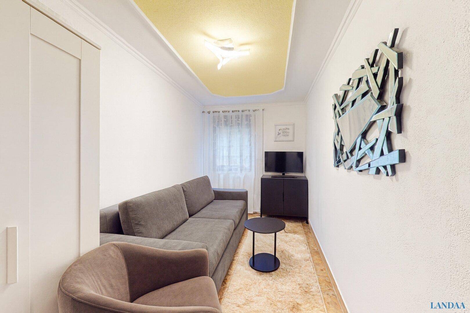 Gemütliches Wohnzimmer mit Sofa, Sessel und modernem Dekor, ideal zum Entspannen.