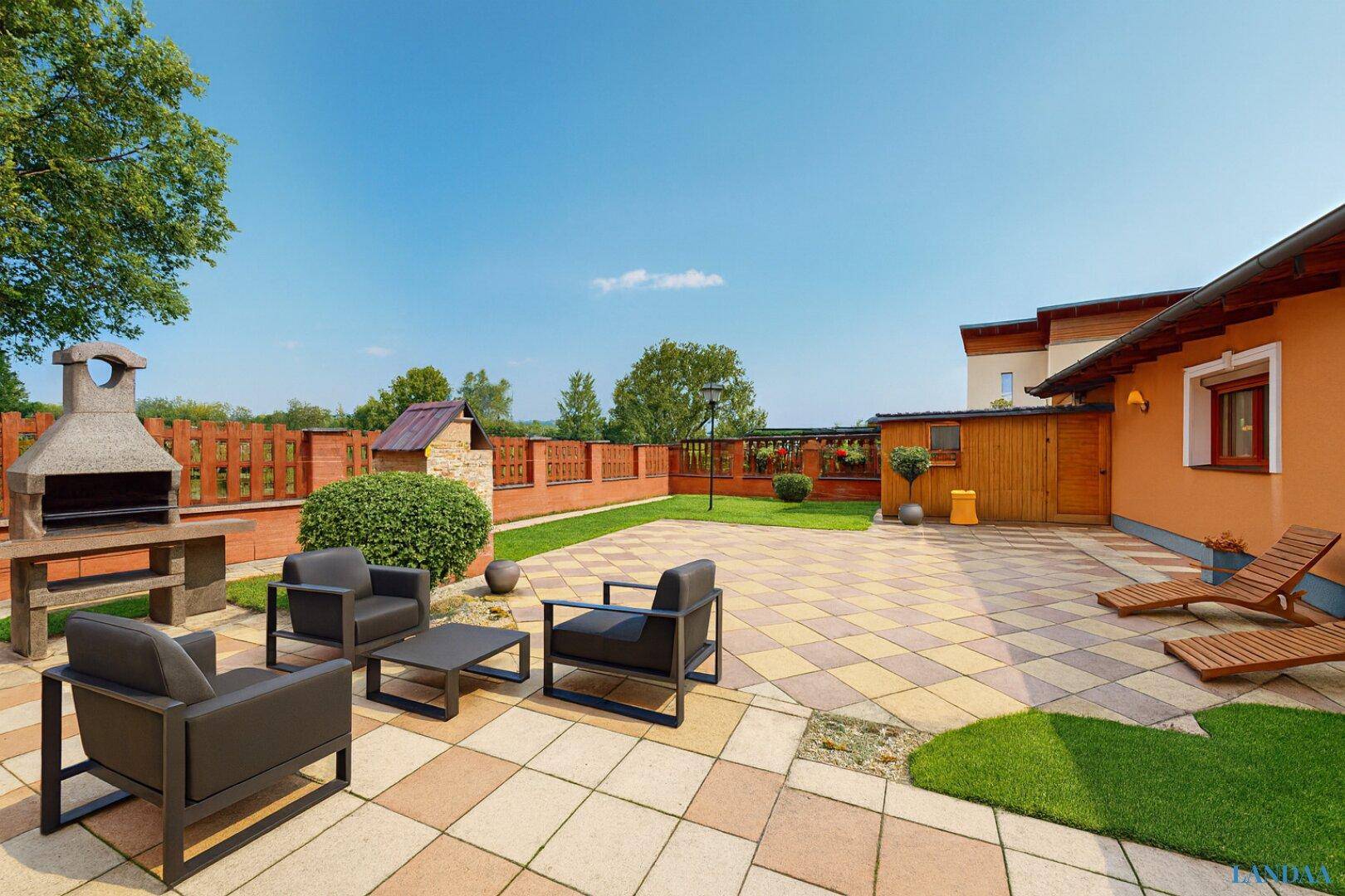 Geräumige Terrasse mit Grillplatz und bequemen Gartenmöbeln, ideal für entspannte Stunden im Freien.