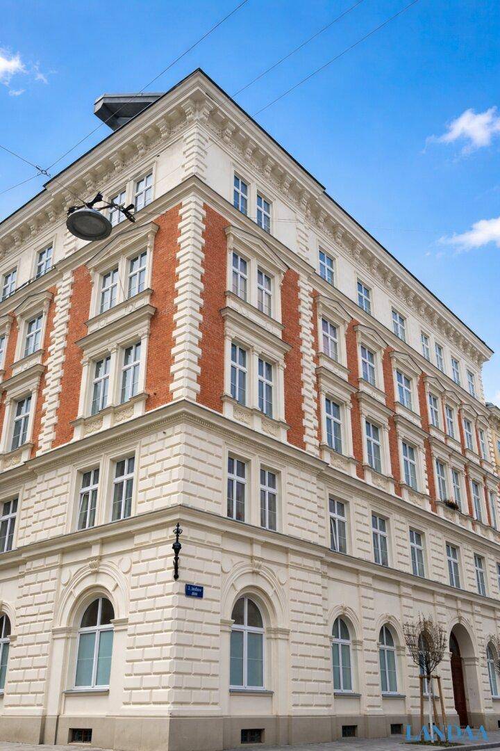 Eckansicht eines eleganten Altbaus mit klassischer Architektur und vielen Fenstern.