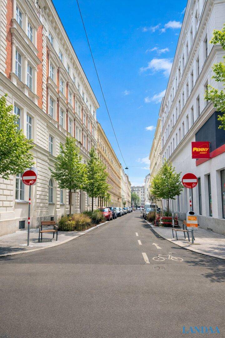 Ruhige Stadtstraße mit Bäumen und historischen Gebäuden, bietet eine angenehme Wohnumgebung.
