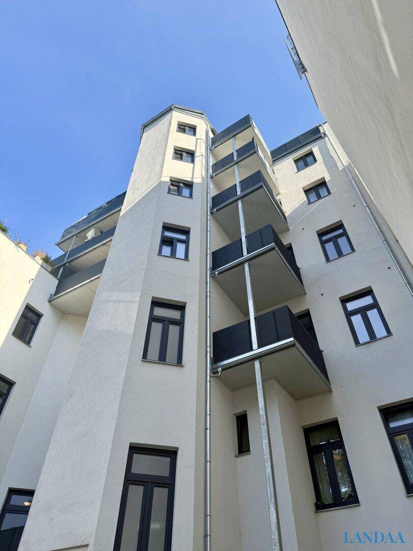 Fassade eines Gebäudes mit mehreren Balkonen und moderner Architektur.