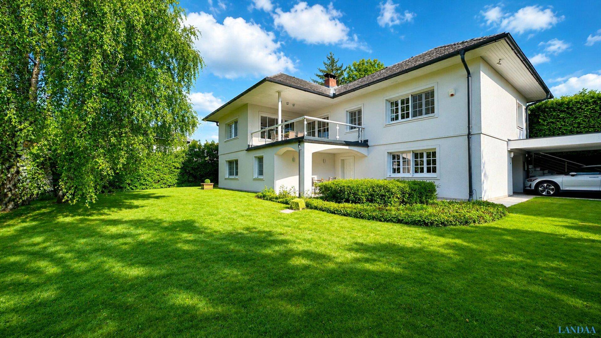 Großzügiges Einfamilienhaus mit weitläufigem, grünem Rasen und altem Baumbestand.