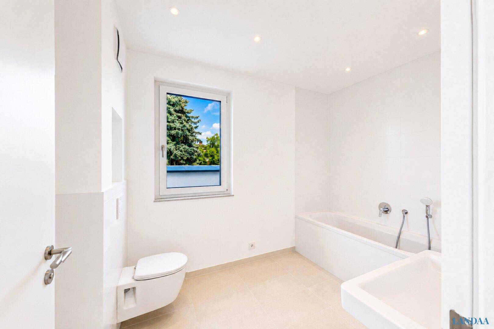 Modernes Badezimmer mit Badewanne, wandhängendem WC und Fenster für natürliche Belüftung.